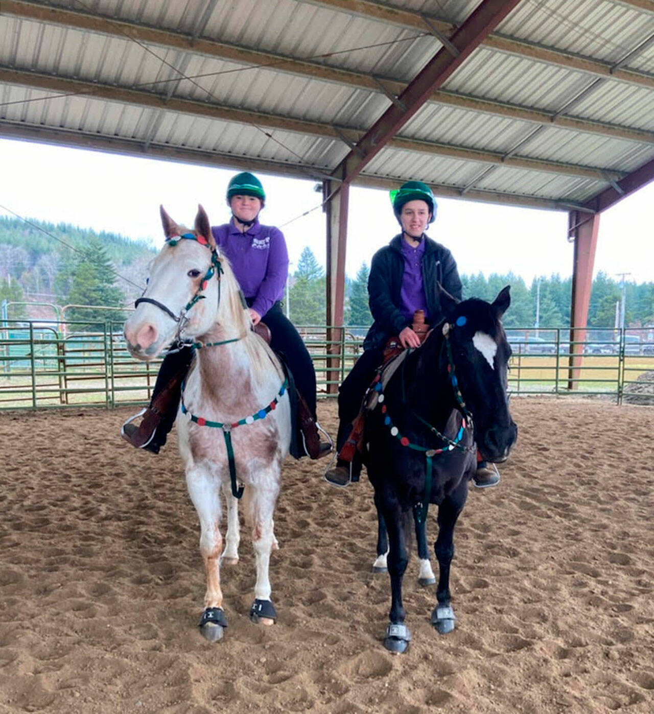 Sequim equestrians Joanna Seelye, left and Mia Kirner getting ready to compete in the Working Pairs event at their team’s second meet of the season, held Feb. 24-27 in Elma. The duo placed third. Submitted photo