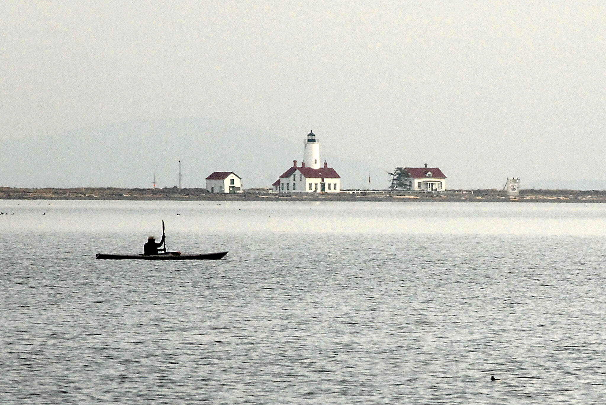 Photo by Keith Thorpe/Olympic Peninsula News Group
Ken Lincoln of Port Townsend kayaks across Dungeness Bay against a backdrop of the New Dungeness Lighthouse on March 26 just north of Sequim. Lincoln said he was paddling out from Cline Spit to meet a group of other kayakers who were putting in at Port Williams.