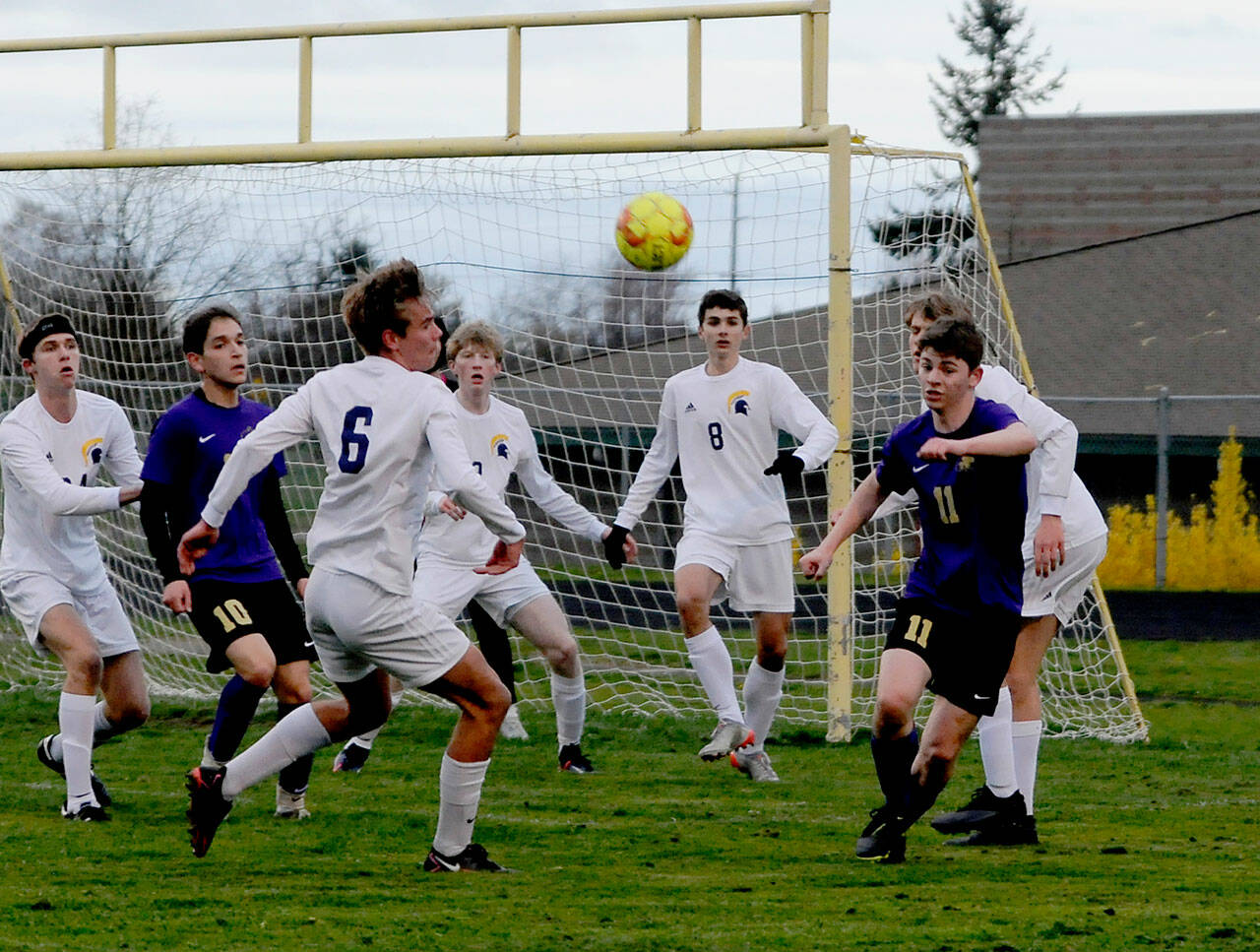 As teammate Rafael Flores (10) looks on Sequim’s Ethan Knight and Spartan Calvin Moe (6) look to track down a deflected ball deep in opponent territory in a 3-0 loss to Bainbridge on March 29. Sequim Gazette photo by Michael