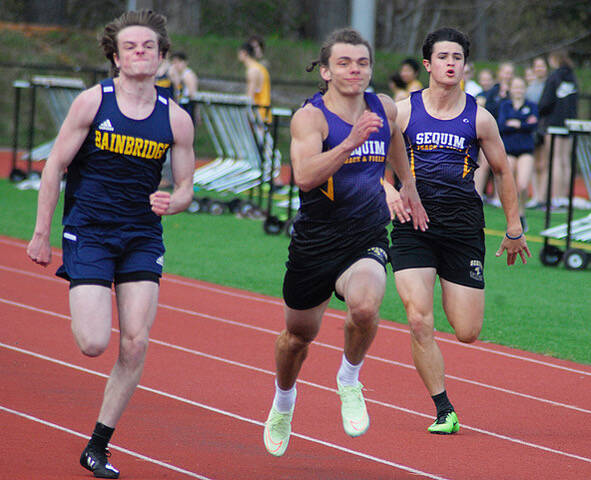 Sequim’s Tyler Mooney, center, and Henry Hughes, right, race for a top spot against Bainbridge’s Mathurin Le Dorze and others in the 100-meter race on April 14 in Kingston. Le Dorze placed first in 11.75 seconds, followed by Mooney (11.88), Bainbridge’s Micah Bryant (12.31) and Hughes (12.48). Photo taken by Joanne Carroll-Huemoeller