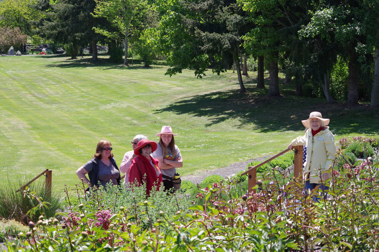 Dona Brock in the garden with peony buds. Photo by Leslie A Wright