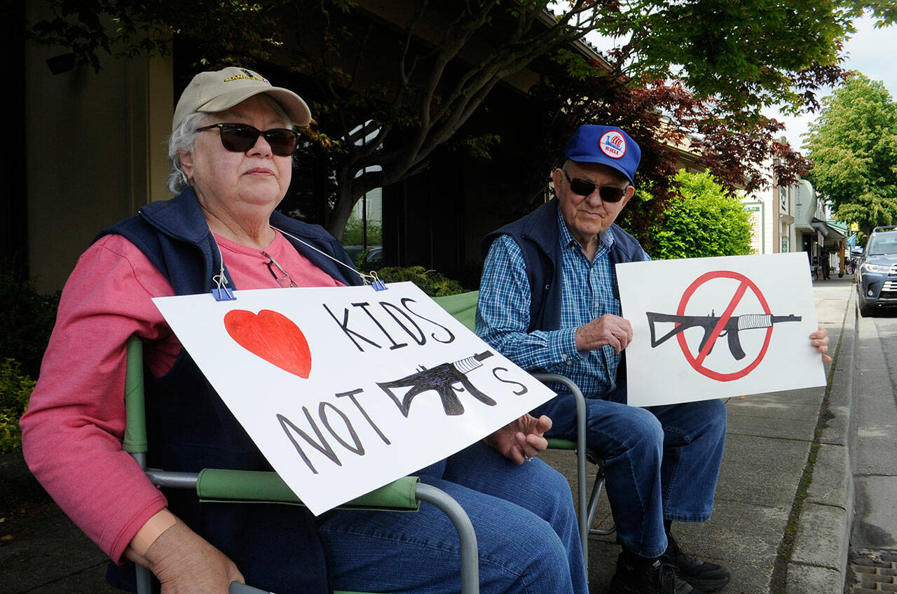 Sequim Gazette photo by Matthew Nash
Jan and Eldon Dennis of Sequim sat on June 11 along Washington Street for the 2022 March for Our Lives with signs they’ve kept since the 2018 shooting at Marjory Stoneman Douglas High School in Parkland, Fla. “We’re not anti-gun. We want to let our community know how we feel, especially about assault guns. We would like them banned,” said Jan, a retired nurse from Juneau, Alaska. “We’re anti-easy accessibility,” said Eldon, a retired chemistry and physics teacher.