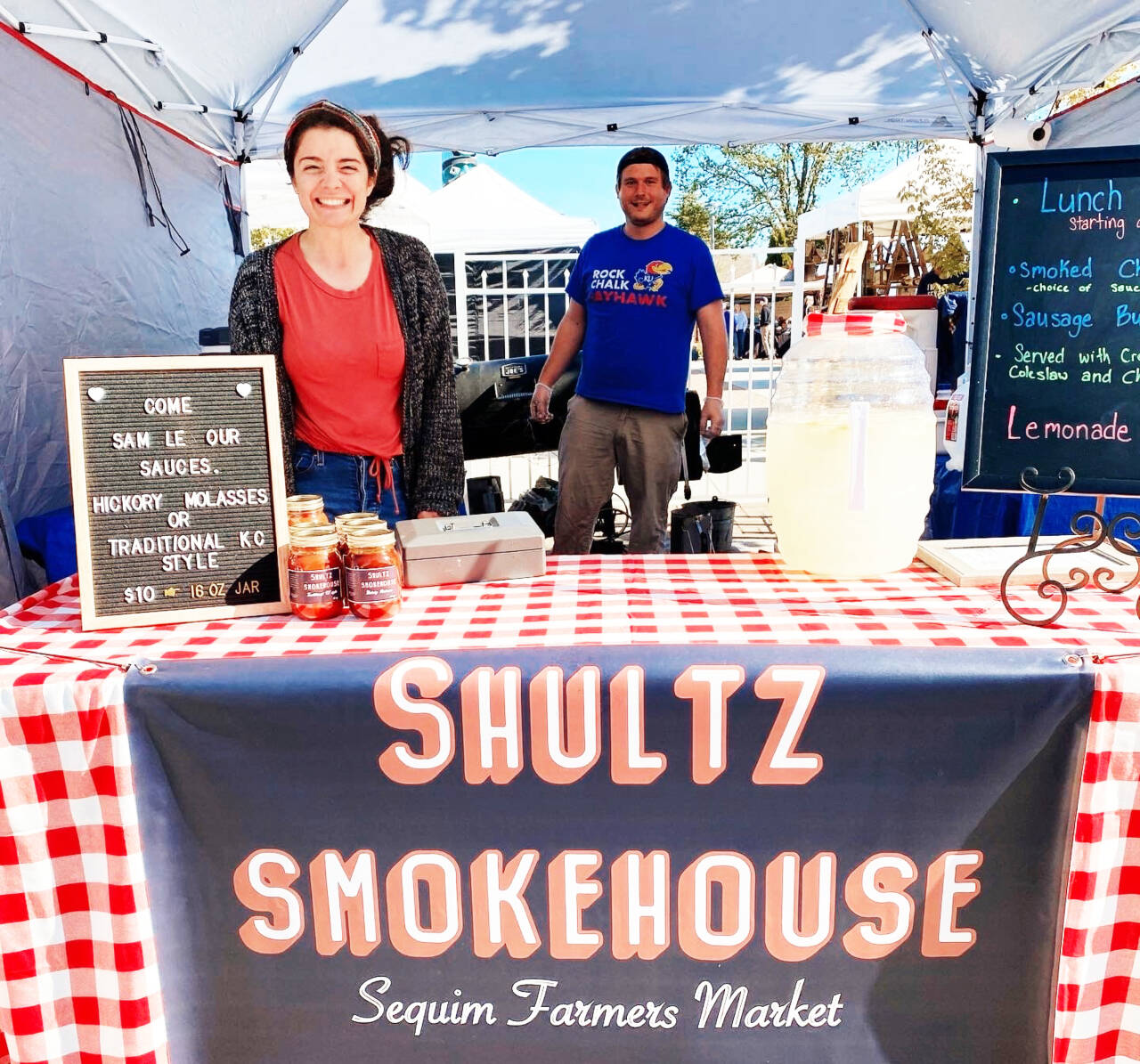 Photo by Emma Jane Garcia/Sequim Farmers & Artisans Market / Alexis Lobdell and Steve Shultz offer Kansas City-styled, slow-cooked meats, tangy and spicy sauces, and more at their Sequim Farmers & Artisans Market booth.