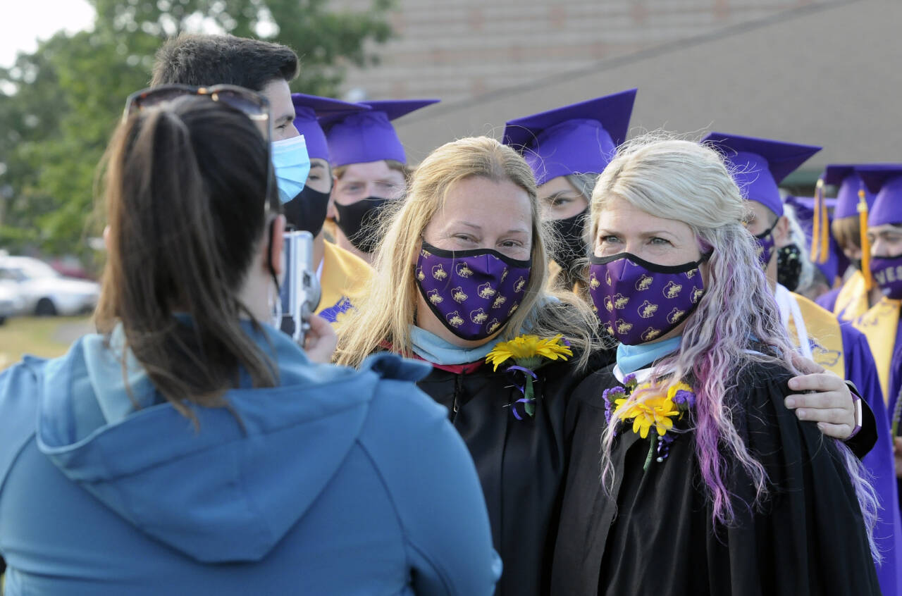 Sequim Gazette file photo by Michael Dashiell / Erin Fox, left, poses for s photo with fellow Sequim High School staffer Melee VenderVelde at the 2021 SHS graduation ceremony. A Sequim High graduate, Fox was named the school’s principal on Aug. 15.