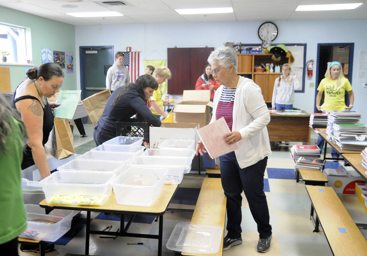 Sequim Gazette file photo by Michael Dashiell / Volunteers at Back to School Fair at the Sequim Boys & Girls Club organize school supply kits for local students in 2018. This year’s event, set for Aug. 27, features a drive-through and on-the-field fair at the Sequim School District stadium on West Fir Street.