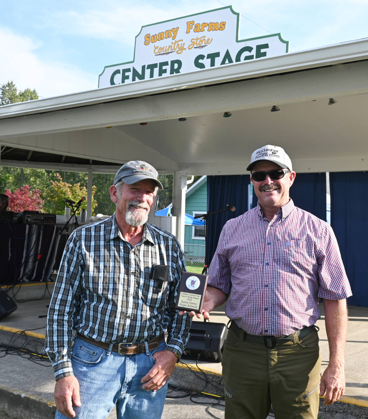 Sequim Gazette photos by Michael Dashiell
Jeff Schmidt, right, and Kerry Lux display the 2022 Farm Family of the Year award bestowed to Schmidt’s late father, Roger, at the Clallam County Fair on Aug. 18. Roger Schmidt, a longtime farmer, grocer, family man and yo-yo champion, founded Sunny Farms Country Store. Lux has farmed for the Schmidt family for more than 33 years.