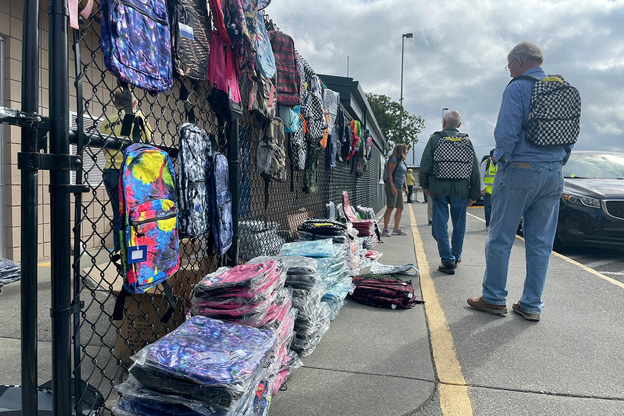 Sequim Gazette photo by Matthew Nash/ Volunteers ready backpacks for distribution outside Helen Haller Elementary during the Back to School Fair on Aug. 27.