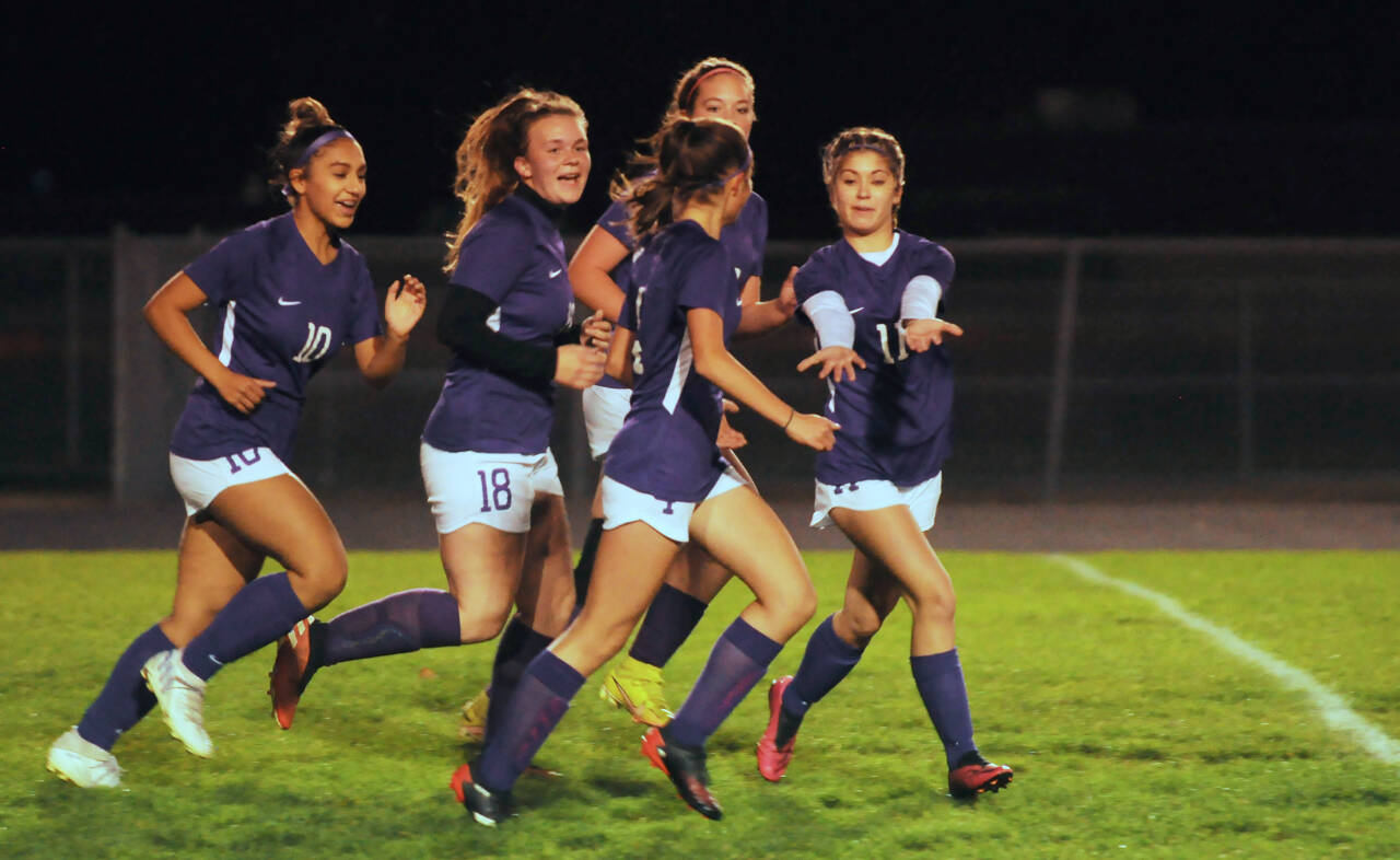 Sequim Gazette photo by Michael Dashiell / Sequim teammates, from left, Jenny Gomez, Jenna Mason, Hailey Wagner (obscured) and Aliyah Weber celebrate Raimey Brewer, front, after her early goal put the Wolves up 1-0 on Kingston on Oct. 27. The Wolves went on to a 4-0 victory.