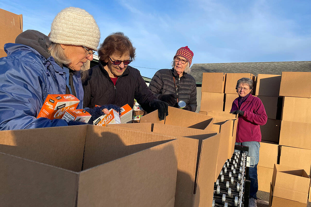 Volunteers with Sequim Seventh-day Adventist Church, from left, Jadie Henton, Dawn Rowe, Linnea Balkan and Eloise Gatchet load and pack boxes for the Family Holiday Food Bag Distribution program. They helped prepare 850 boxes for Christmas meals.