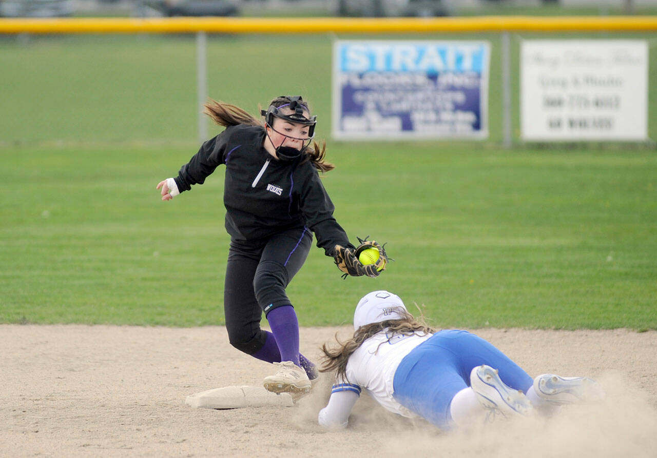 Sequim Gazette photo by Michael Dashiell / Sequim shortstop Hannah Bates, left, puts the tag on an Olympic runner in an April 13 league match-up in Sequim.