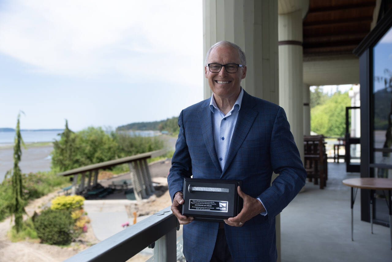 Photo by Jesse Major/Rails-to-Trails Conservancy / Washington state Gov. Jay Inslee poses with the Doppelt Family Rail-Trail Champion Award presented to him by the Rails-to-Trails Conservancy on June 7.