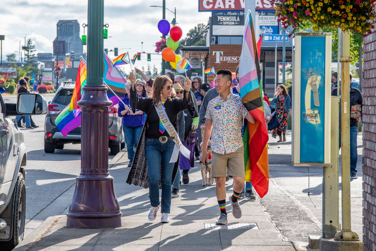 Sequim Gazette photo by Emily Matthiessen / Sequim's second annual Pride march and celebration took place on Friday evening. Grand Marshal Lorie Fazio and Pride committee volunteer David Ham lead the march up and down Washington Street with a happy crowd behind them.