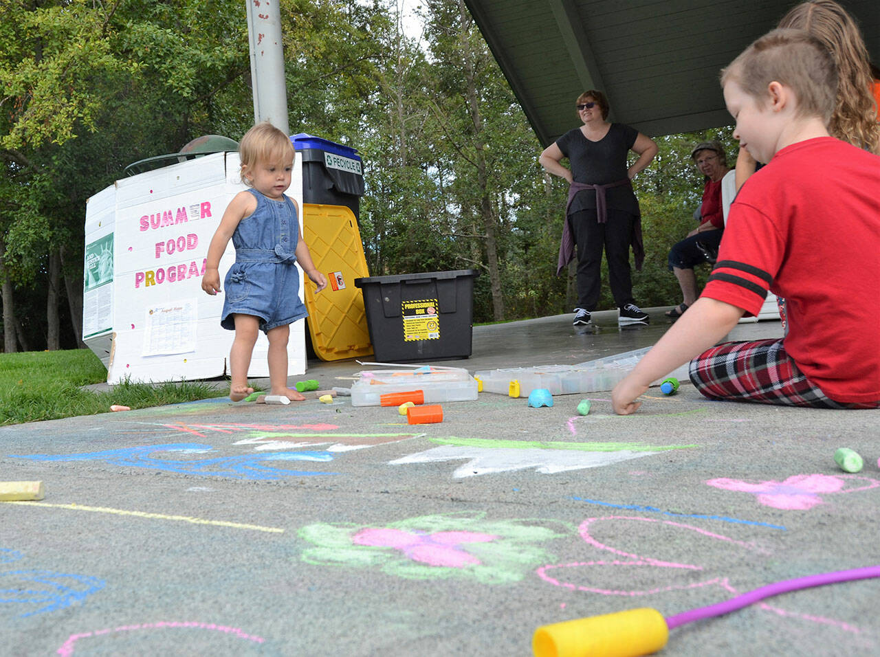 Sequim Gazette file photo by Matthew Nash/ Children enjoy chalk drawing after eating meals provided through the USDA Summer Food Program in 2018. The program continues this summer with free lunch on weekdays at several locations, and breakfasts at the Boys & Girls Clubs in Sequim and Port Angeles.