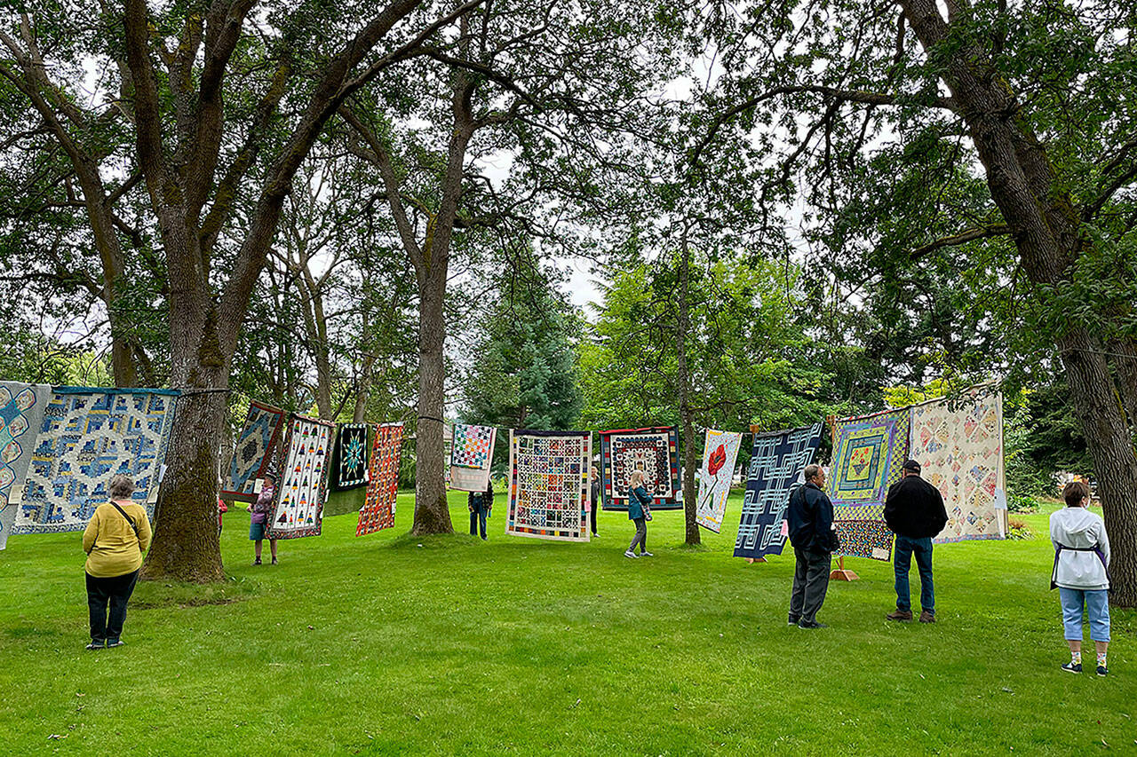 Sequim Gazette file photo by Matthew Nash
This year, organizers of the Sunbonnet Sue Quilt Club’s annual show on July 22 anticipate hanging 180-plus quilts between trees and on rafters at Pioneer Memorial Park.