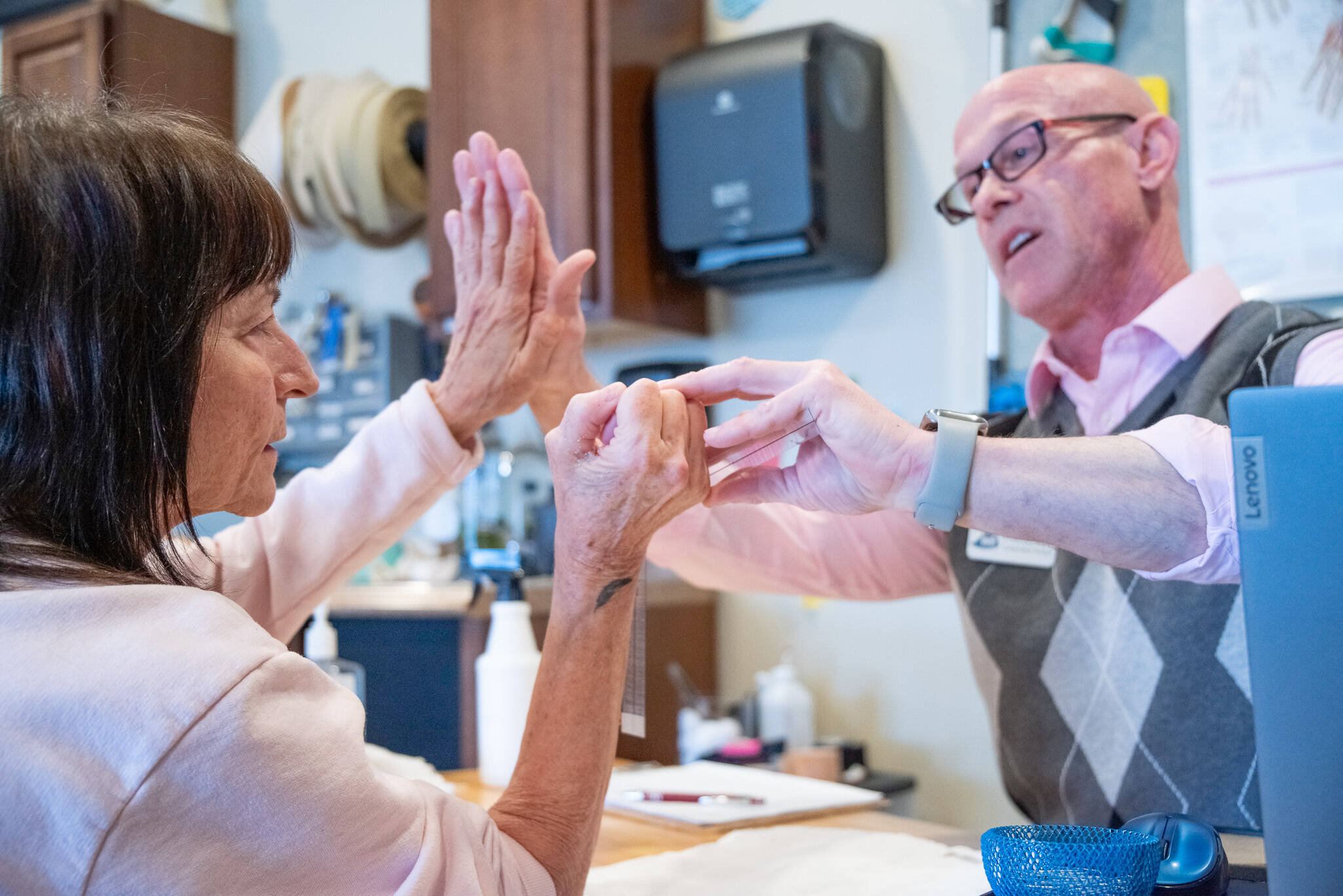 SEQUIM GAZETTE Photos by Emily Matthiessen
Sandy Pufky-Negus and her hand therapist, Aaron Staeben, share a high five as he assesses her wrist’s range of motion with a goniometer measurement device.