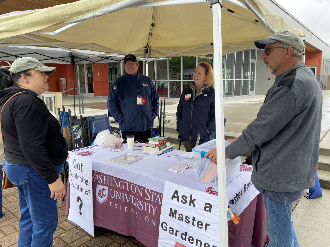 Photo courtesy of WSU Extension Clallam County Master Gardeners
Master Gardeners Ed Adams, Lorraine Eckard and Keith Dekker talk with a local gardener at the Sequim Farmers and Artisans Market Plant Clinic booth.