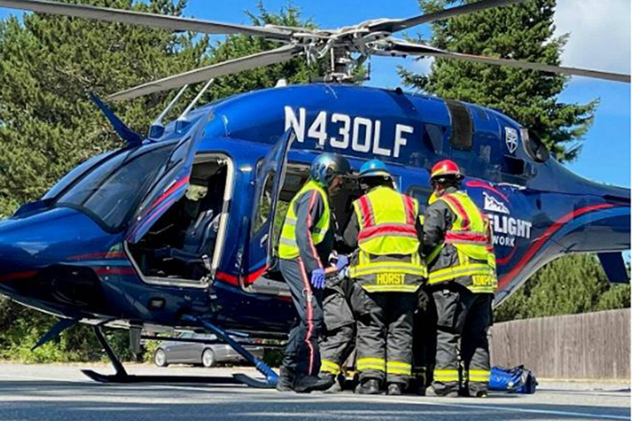 Photo by Jared Romberg / Firefighters help a patient involved in a three-vehicle wreck on US. Highway 101 into a LifeFlight helicopter on Aug. 7.