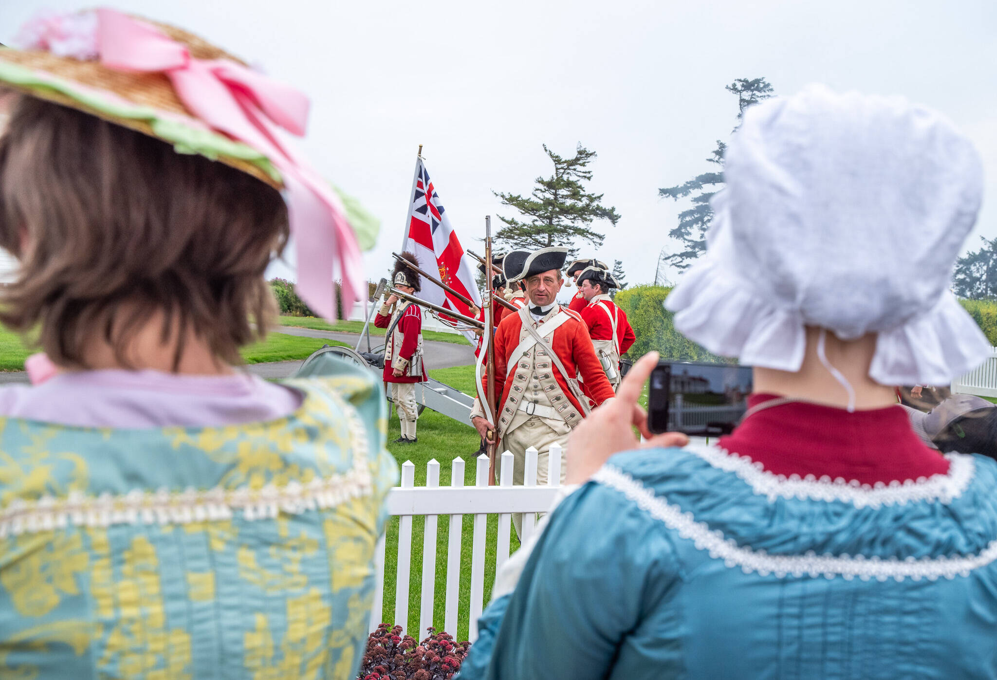 Sequim Gazette photoS by Emily Matthiessen
Spectators in period costumes watch and document a demonstration of Revolutionary War era British artillery technique at the Northwest Colonial Festival this past weekend, highlighting the juxtaposition between the modern and historical that can be seen throughout the festival.