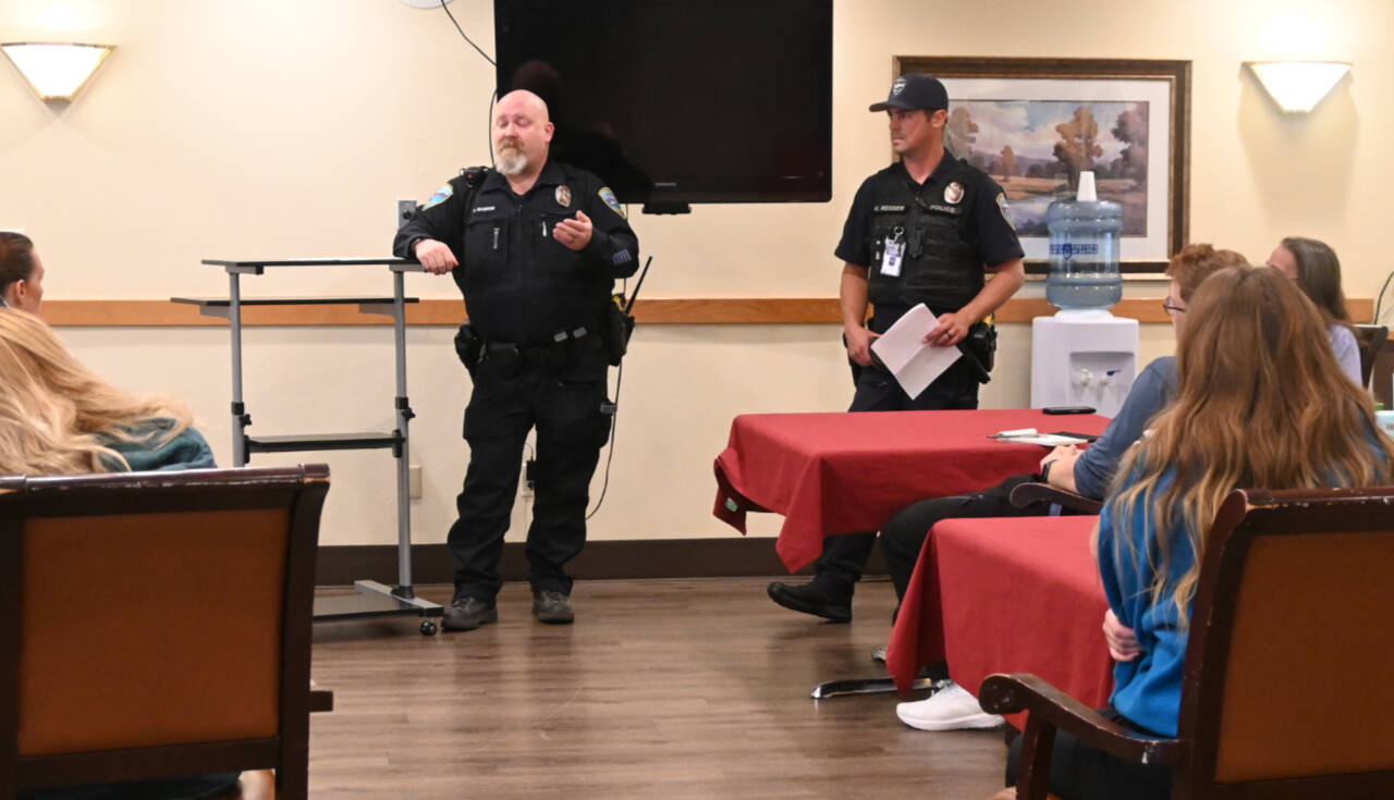 Sequim Gazette photo by Michael Dashiell / Sequim Police officers Devin McBride, center, and Kyle Resser talk with staff at Avamere Olympic Rehabilitation of Sequim prior to an active shooter drill on Sept. 7.