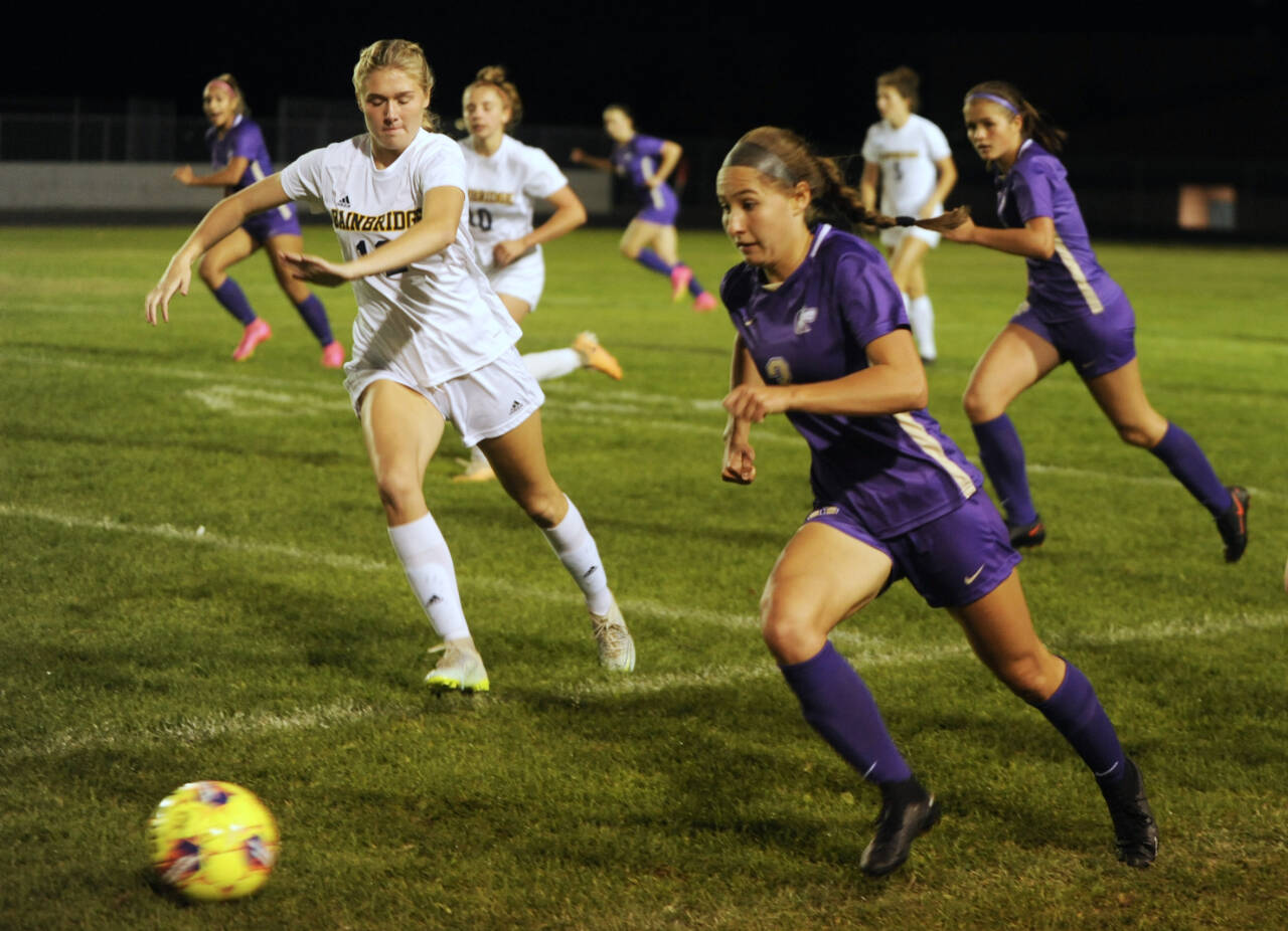 Sequim Gazette photos by Michael Dashiell
With teammate Sasha Yada, left, racing into Spartan territory, Sequim’s Taryn Johnson looks to advance the ball against Bainbridge in a Sept. 26 Olympic League match-up.