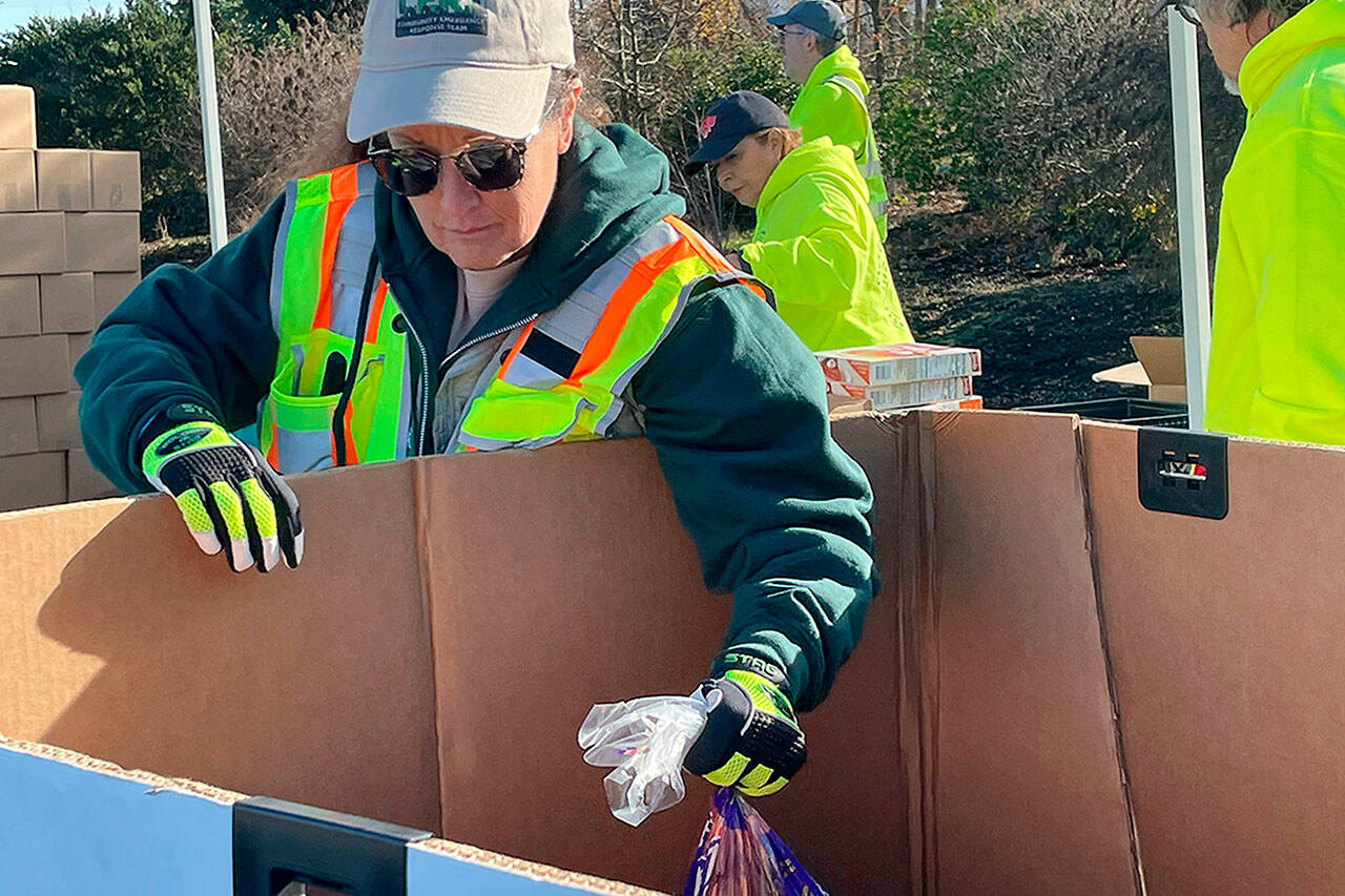 Sequim Gazette file photo by Matthew Nash
Laura Johns, a Community Emergency Member Team (CERT) member, readies some food for the Family Holiday Meal Bag Distribution program on Nov. 17. The event returns to Carrie Blake Community Park offering meals for Christmas from 11 a.m.-2 p.m. Friday, Dec. 15.