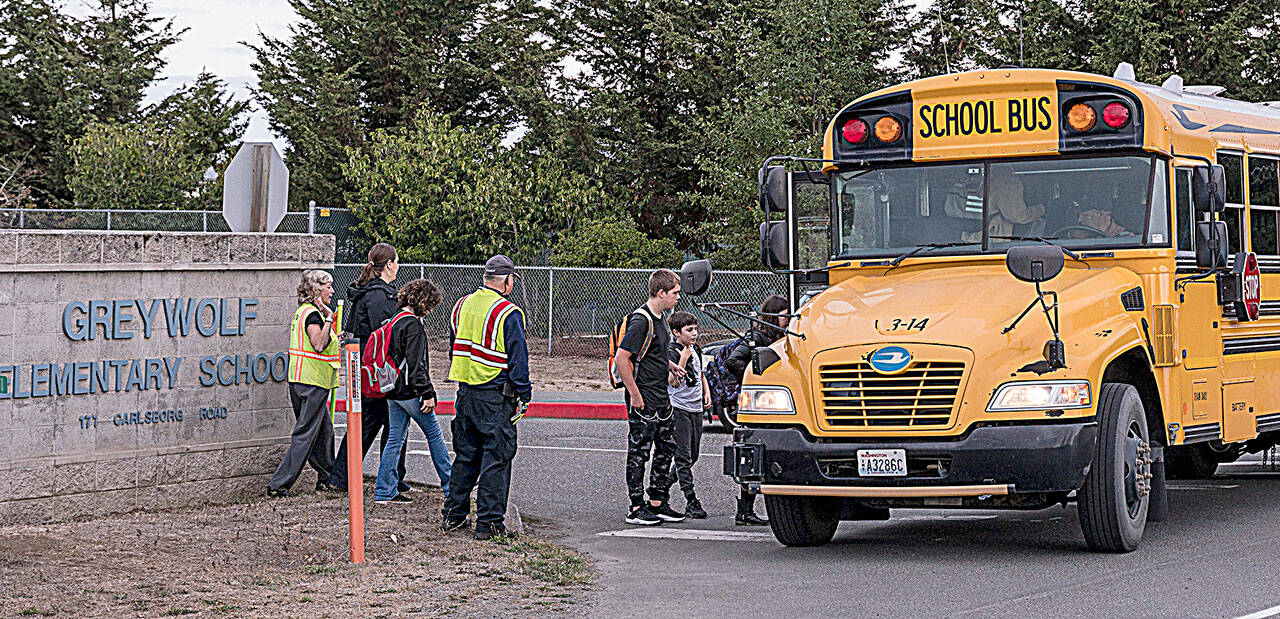 Photo courtesy of CERT
Community Emergency Response Team (CERT) members help students ride the bus in September while also helping direct traffic for parents at drop-off/pick-up for the K-2, 3-5 reconfiguration of Greywolf and Helen Haller Elementary schools. Sequim School District officials have started conversations to consider changing bus routes to improve attendance and behavior among other things.