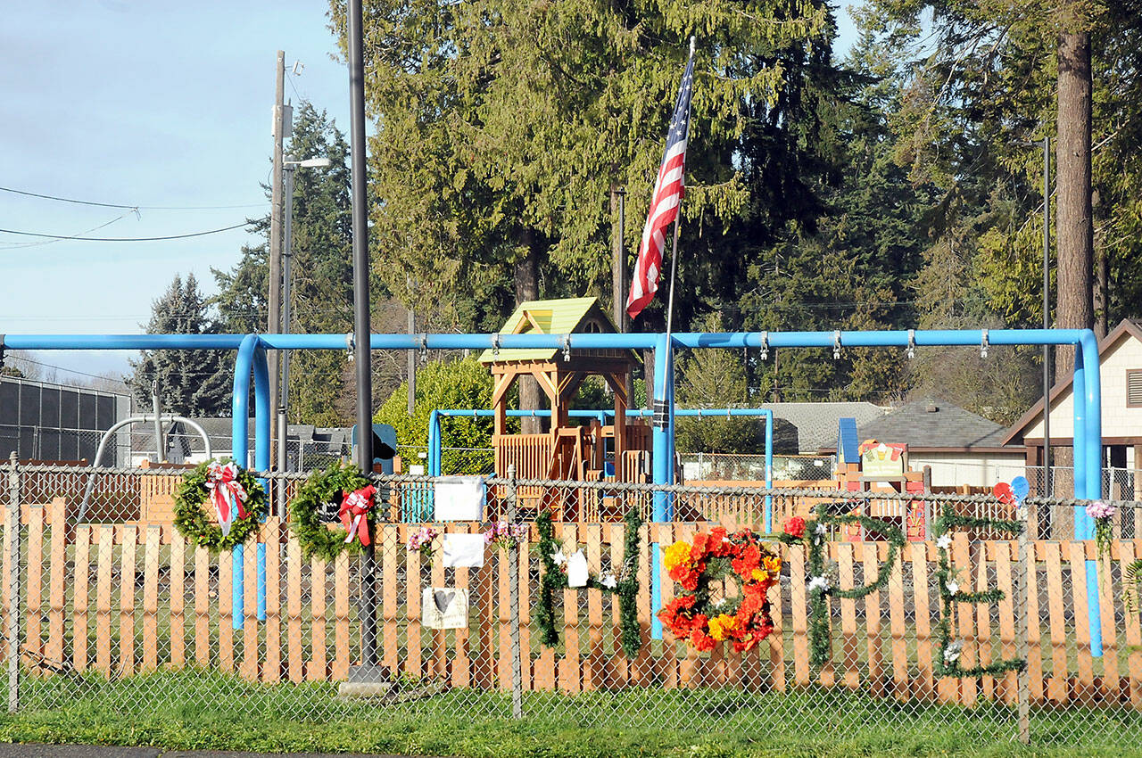 Photo by Keith Thorpe/Olympic Peninsula News Group 
Wreathes, personal notes and flowers adorn the fence outside the Dream Playground at Erickson Playfield in Port Angeles on Dec. 26 after much of the playground was destroyed by fire the previous week.