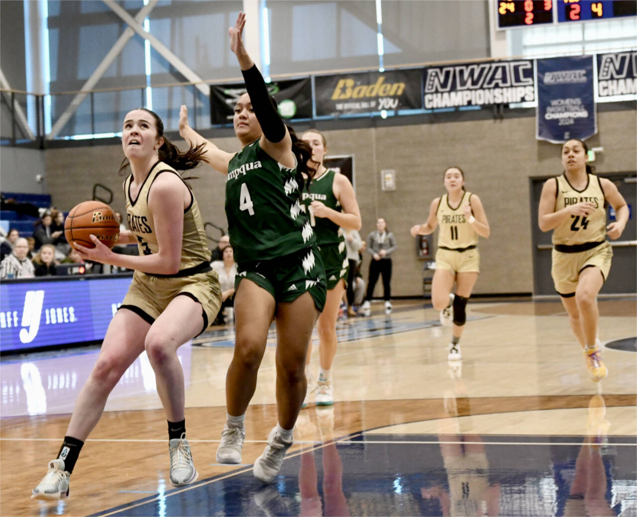 Photo by Jay Cline/Peninsula College / Peninsula College’s Alexa Mackey goes to the rim up against Umpqua’s Amaya Afatasi (4) on March 2 in Pasco. Trailing the play are Peninsula’s Jenilee Donovan (11) and Shania Moananu (24). Umpqua won 73-55.