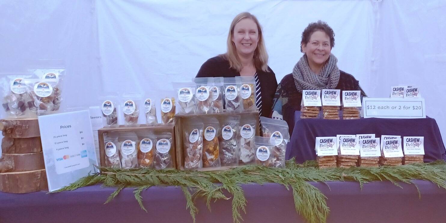 Photo courtesy of WeDo Fudge / Teresa Crecelius of Cascade Caramel, left, Christina Norman of WeDo Fudge are pictured in their booth set up for the Sequim Irrigation Festival. WeDo Fudge and Cascade Caramel open their season of drive-thru candies and prayer on April 30.