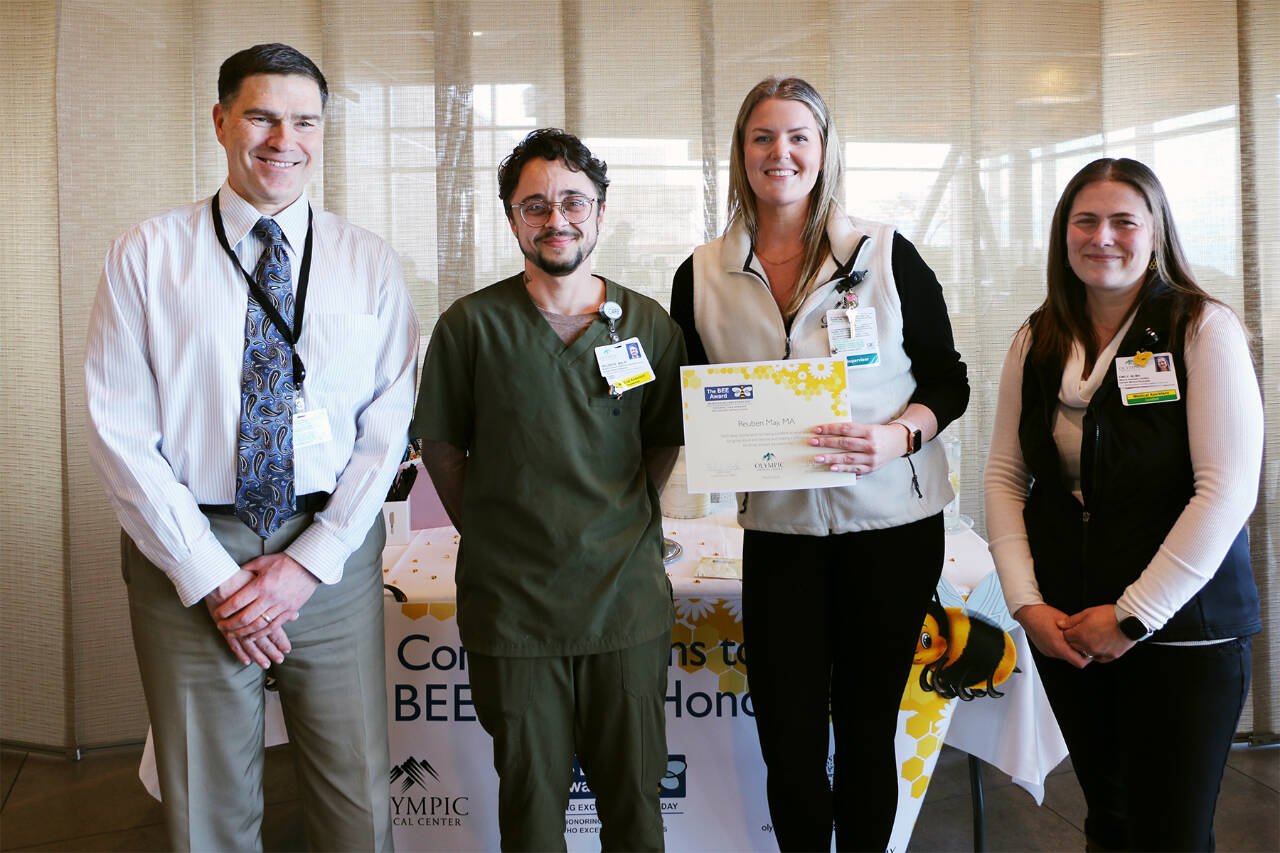 Photo courtesy of Olympic Medical Center / Certified pulmonary medical assistant Reuben May, second from left, receives an OMC BEE (Being Excellent Every Day) Award from (from left) OMC CEO Darryl Wolfe, OMC medical assistant/Specialty Clinic Supervisor Megan Reader and Emily Fry, medical assistant/primary care and BEE committee chair.