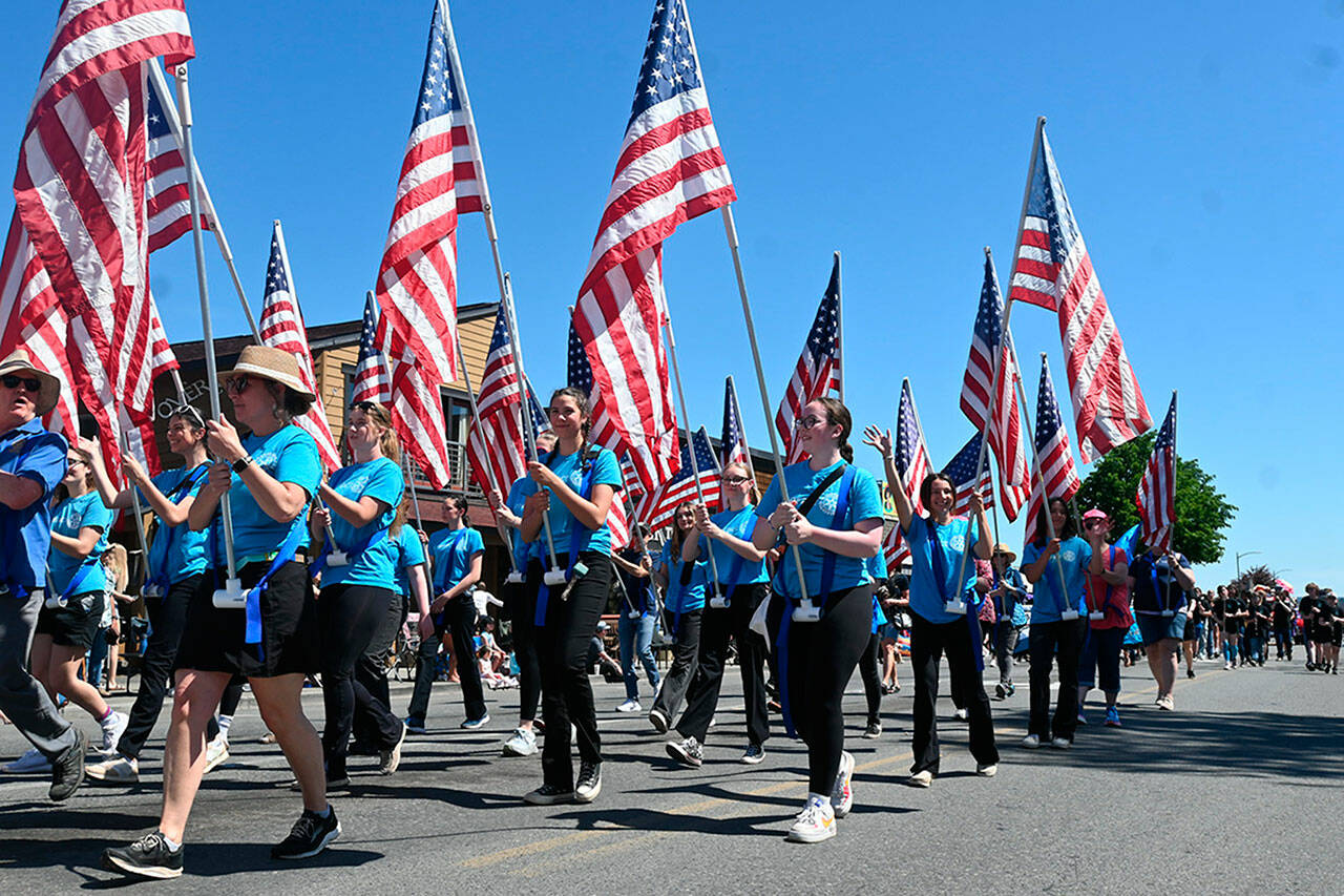 Sequim Gazette photo by Michael Dashiell
Sunrise Rotary Club and Interact Club members march in the Grand Parade on May 11. Rotarians have sought sponsorships for flags to be placed in front of homes and businesses on five holidays with funds supporting community projects.