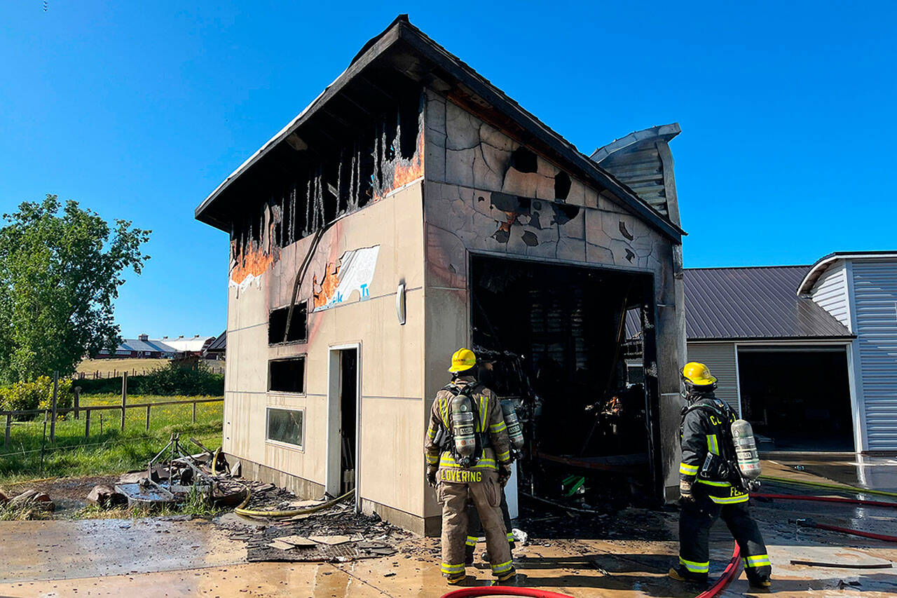 Photo courtesy Clallam County Fire District 3
Firefighters inspect a garage fire north of Sequim on May 19 that destroyed a trailer inside.