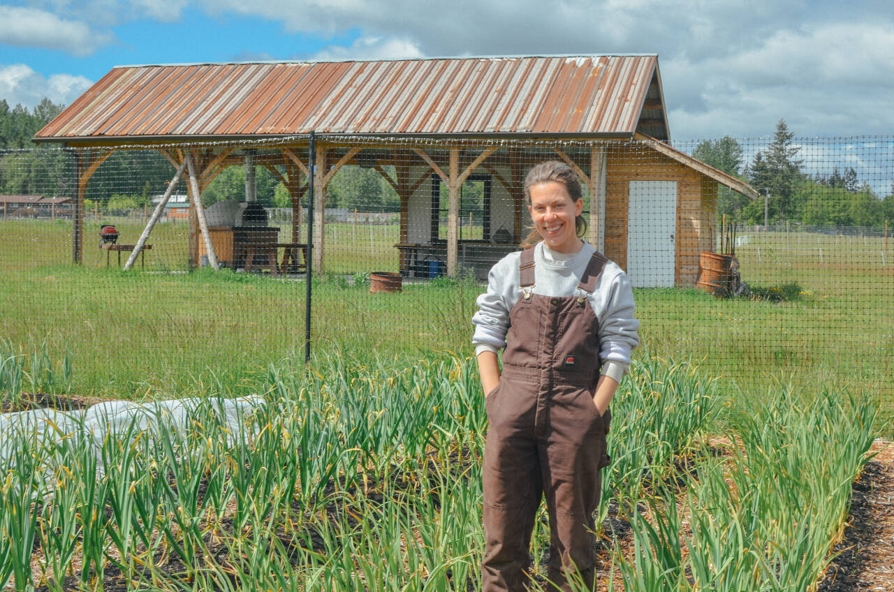 Sequim Gazette photo by Elijah Sussman / Jenson, farmer and SisterLand Farm Pride Picnic organizer, stands in a field of garlic on their farm in Port Angeles on May 22.