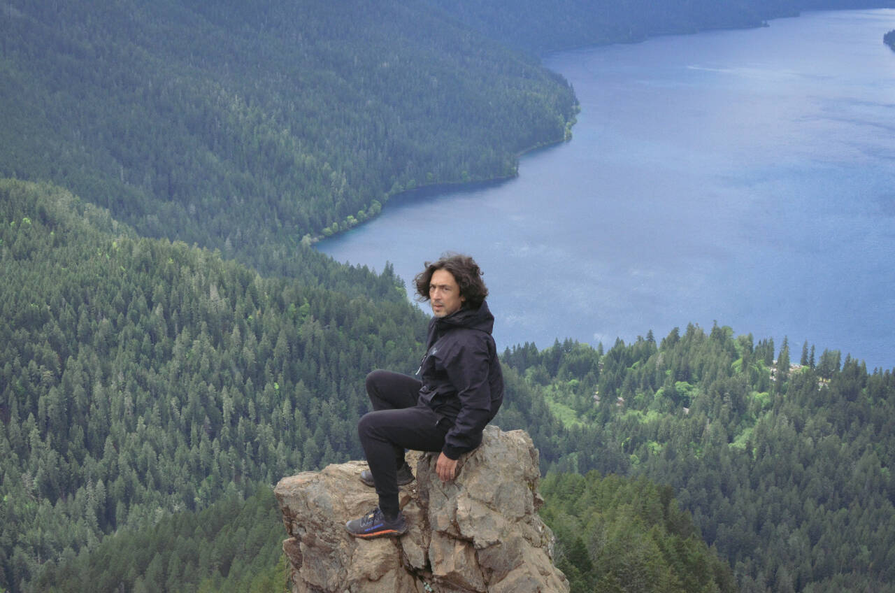 Sequim Gazette photo by Elijah Sussman / Ian Maksin sits on a favorite photo rock at Storm King viewpoint on a May 28 hike.