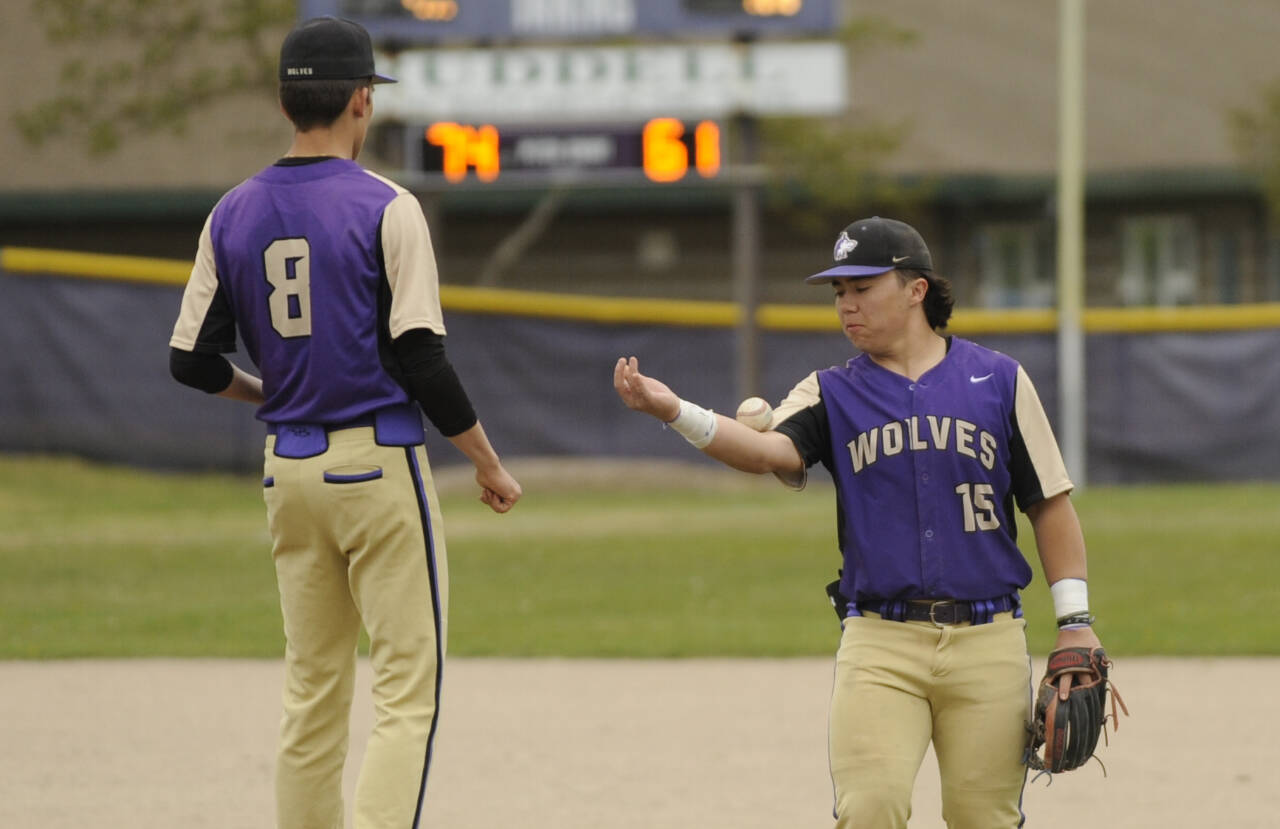 Sequim Gazette file photo by Michael Dashiell / Sequim third baseman Ayden Holland, right, bounces the ball to his pitcher Ethan Staples in between innings of an April 24 league match-up with North Mason. Holland, a senior, was selected to play in an All-State game in Yakima later this month.