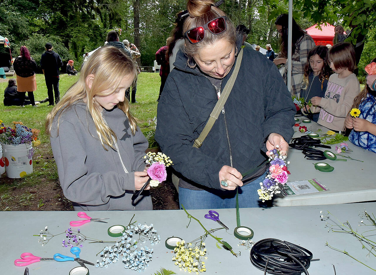 Photo by Keith Thorpe/Olympic Peninsula News Group
Elora Wilson, 10, and her mother, Eria Wilson of Sequim, create solstice crowns to wear on their heads at a craft table in Webster’s Woods Sculpture Park at the Port Angeles Fine Arts Center during the Summertide Solstice Art Festival on June 15. The event featured music entertainment, poetry reading, crafts, food and games as a celebration of the upcoming beginning of summer and the longest day of the year.