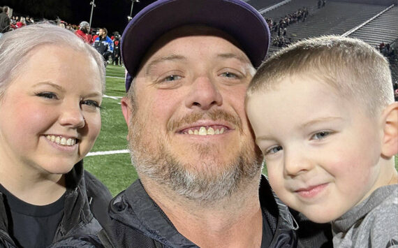 New Sequim athletic director/head football coach Ian Henley takes a family photo with his wife Jessica and son Rhys after a football game.