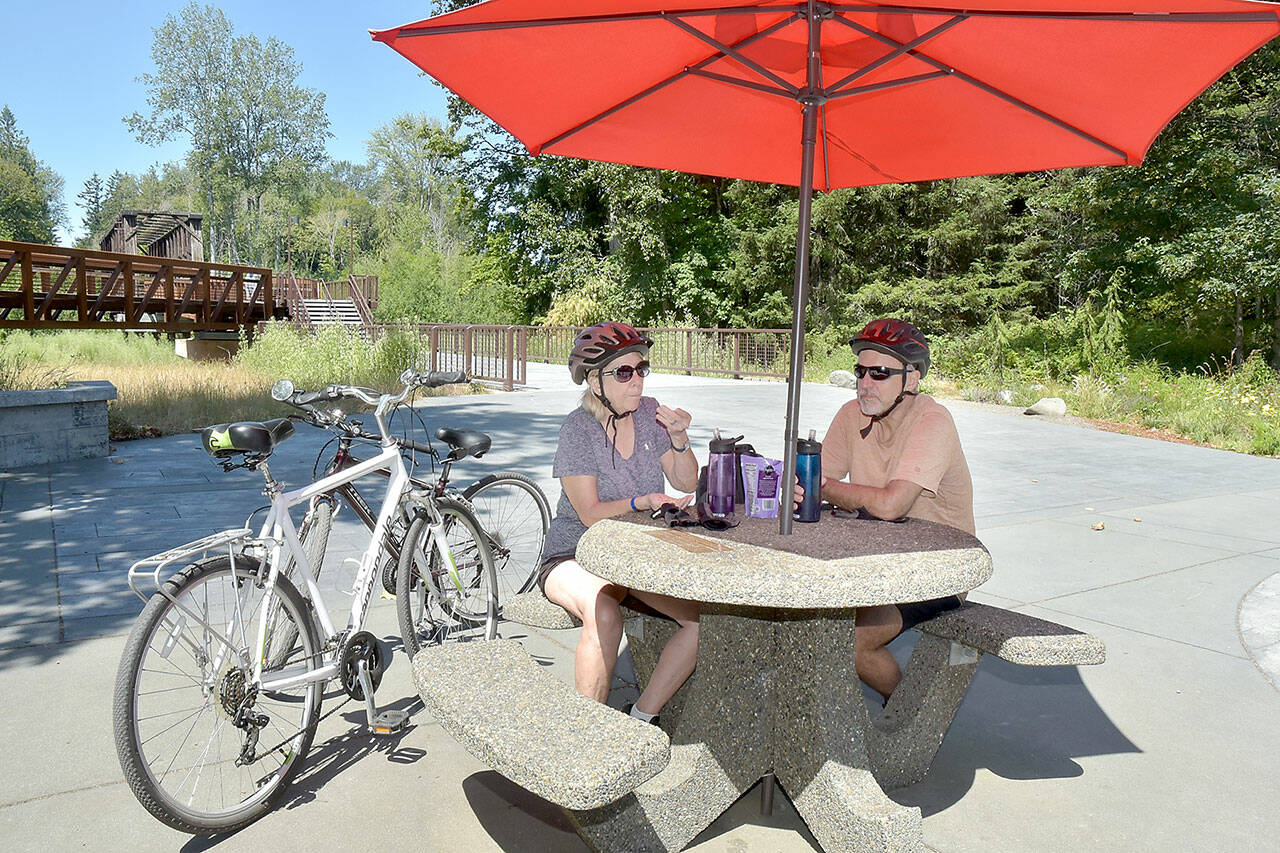 Phpto by Keith Thorpe/Olympic Peninsula News Group
Twyla and Doug Falsteisek, who split their time between Port Angeles and Sun City West, Ariz., take a break from their bike ride on the patio of the Dungeness River Nature Center along the Dungeness River in Sequim on July 10. The couple took advantage of summer weather for an excursion on the Olympic Discovery Trail.