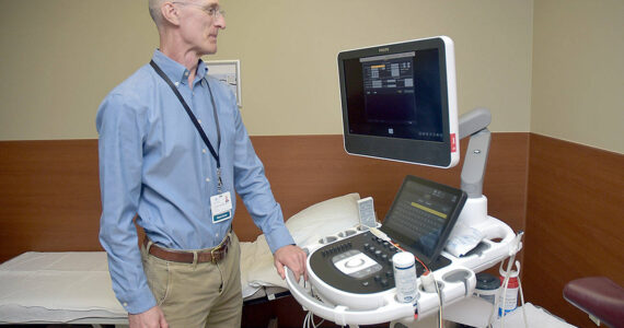 Olympic Medical Heart Center director Leonard Anderson examines a new echocardiograph at the Port Angeles hospital facility. (Keith Thorpe/Peninsula Daily News)
