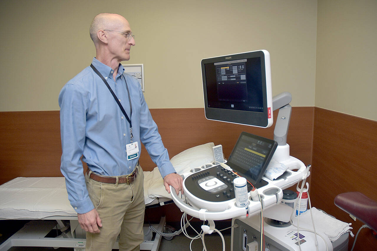 Photo by Keith Thorpe/Olympic Peninsula News Group / Olympic Medical Heart Center director Leonard Anderson examines a new echocardiograph at the Port Angeles hospital facility.