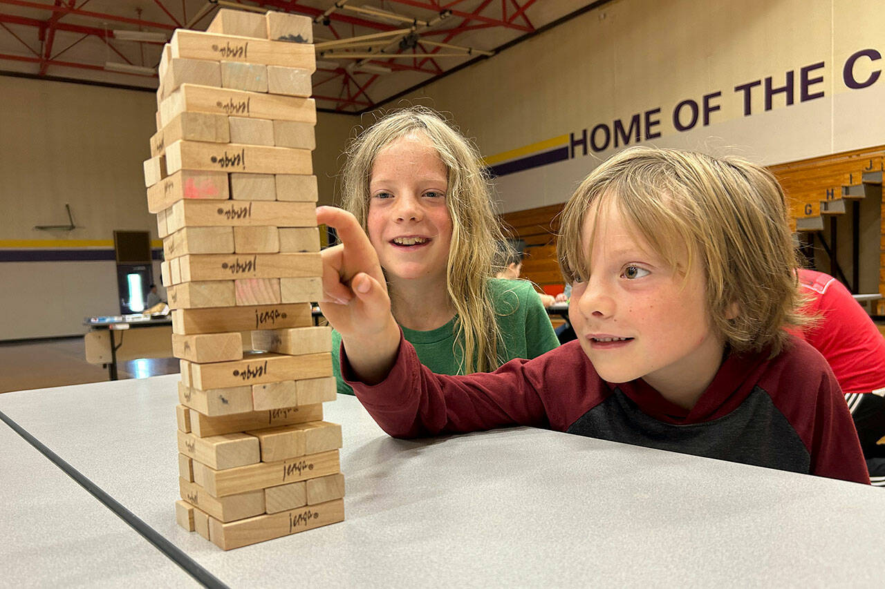 Sequim Gazette photo by Matthew Nash/ Journey, 7, and Fenn, 10, Maynard plan their next moves in a game of Jenga during the Sequim Library’s Discovery Club program on July 18 in the Olympic Peninsula Academy gym.