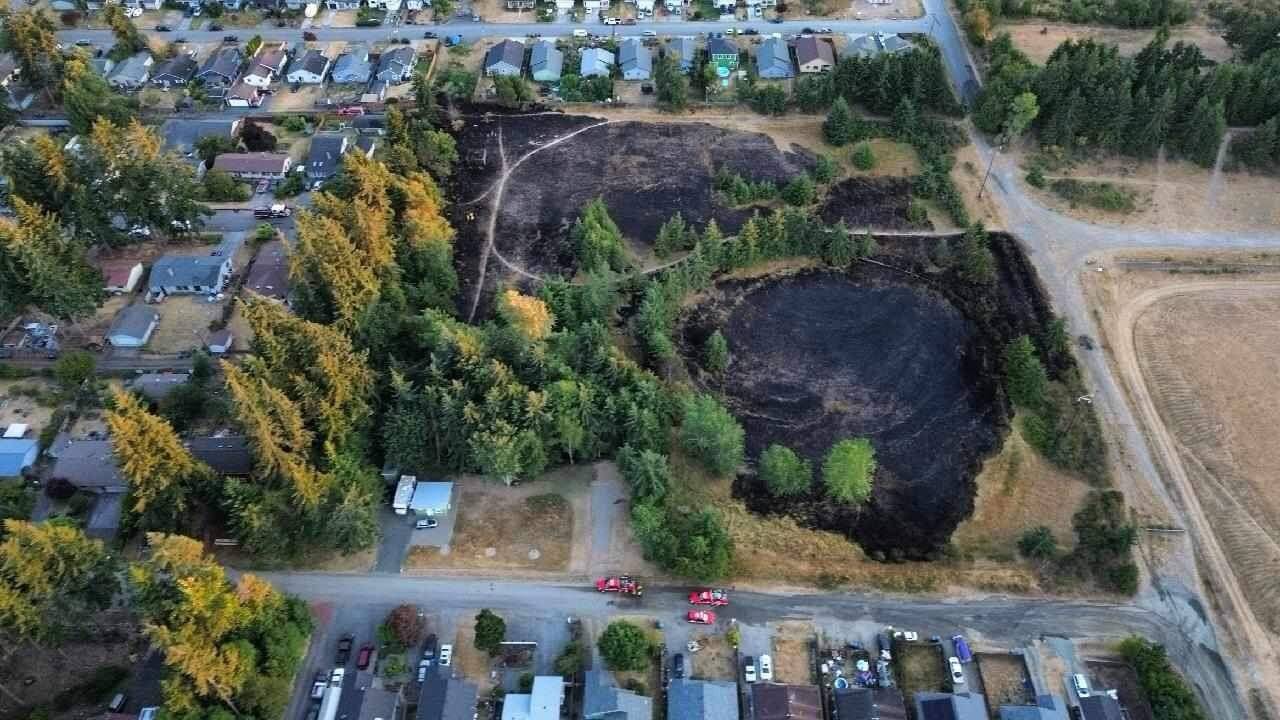 Aerial photo by Brandy Didier / About 5 acres of wildland near homes west of Port Angeles are scorched after a brush fire spread to within about 10 feet of homes on West 13th and West 14th streets on July 22.