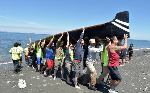 KEITH THORPE/PENINSULA DAILY NEWS
A canoe from Ahousaht First nations of western Vancouver Island is hauled ashore by volunteers on Tuesday on Lower Elwha Clalllam land near the mouth of the Elwha River west of Port Angeles.