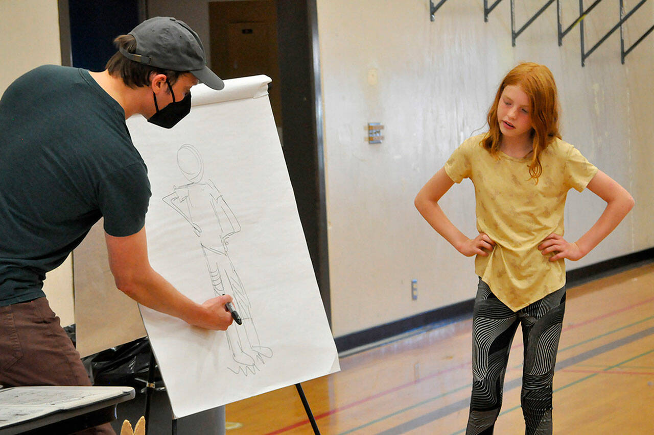 Sequim Gazette photos by Matthew Nash
Cecily Erickson watches as cartoonist Aron Nels Steinke draws her as an anthropomorphic red fox character similar to those found in his “Mr. Wolf’s Class” books. She was one of 20-plus children to participate on July 31 in a lesson through the North Olympic Library System in Sequim on how to make your own comic books. It was fun, Cecily said, and her mom added that she makes a lot of comics at home, too.