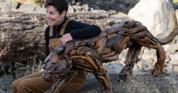 Photo courtesy of Molly Omann / Driftwood artist Molly Omann, poses with her life-sized cougar sculpture, which will be on display at Sequim Museum & Arts in April and during the First Friday Art Walk.