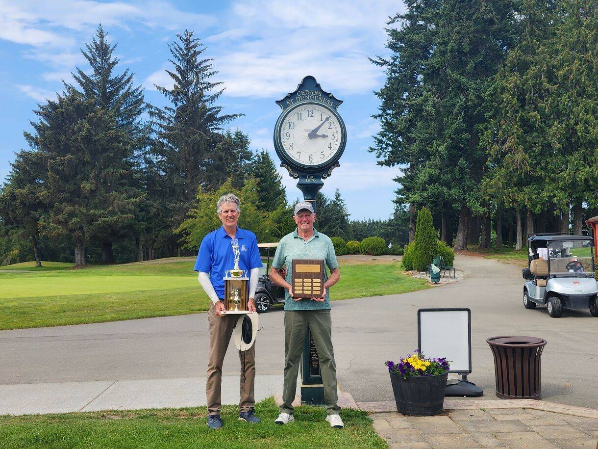 Photo courtesy of The Cedars at Dungeness / Jeff Jones, left, and Rick Towery celebrate division wins at the The Cedars at Dungeness Men’s Club championship on Aug. 17. With a two-day score of 141 (3-under par), Jones won the club title for the fourth consecutive season, edging out Ron Grant; they were tied after 31 holes but Jones took the lead on hole No. 14 and held on. He will be heading to Georgia in March for the event with other club champions from around the U.S. Towery edged out Harry Phillips for the net division title, shooting a 71 gross for a net 59.