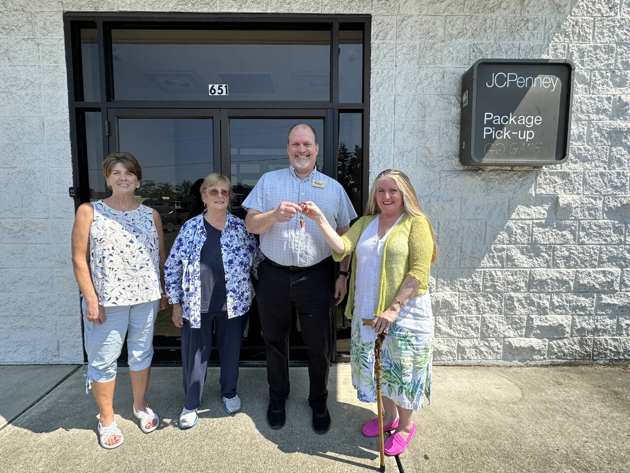 Photo courtesy of Shipley Center / Eileen Schmitz, JACE Real Estate owner and Shipley Center board member, presents the keys of the former JCPenney building at 651 W. Washington St. to Shipley Center executive director Michael Smith following the center’s Aug. 8 purchase of the building. At far left is Joyce Gladen of JACE Real Estate, and second from left is Shipley Center board secretary Margaret Cox.