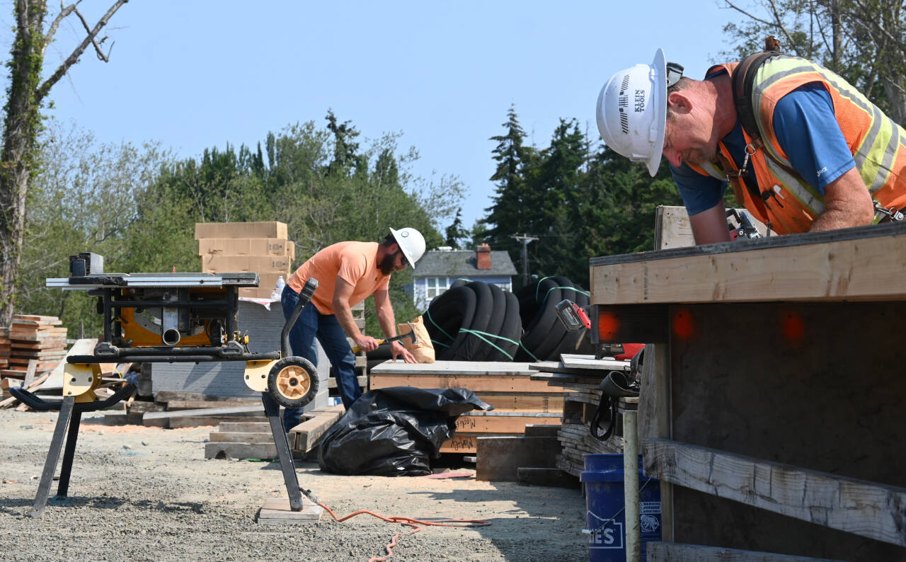 Sequim Gazette photo by Michael Dashiell / Chris Johnson, left, and Robert Bufford, of Nordland Construction Northwest, set up a base to build panels for a bridge as part of the lower Dungeness River floodplain restoration and levee road realignment project on Aug. 9.