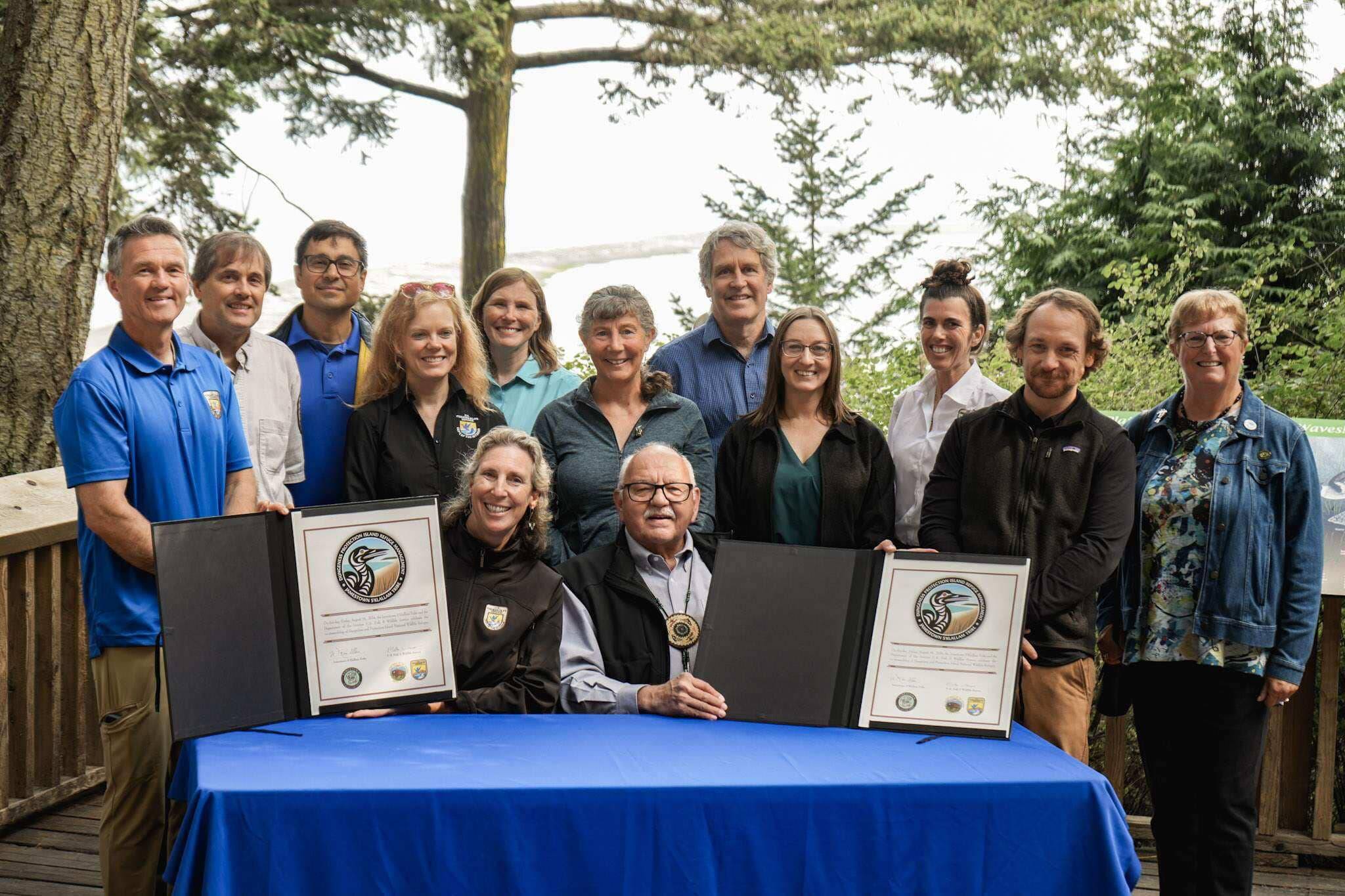 Photo by Jackie Johnson/Jamestown S’Klallam Tribe
Martha Williams, director of the U.S. Fish & Wildlife Service, and Ron Allen, CEO and Tribal Chairman of the Jamestown S’Klallam Tribe (both seated), celebrate the signing of a co-stewardship agreement for the Dungeness and Protection Island National Wildlife Refuges on Aug. 16.