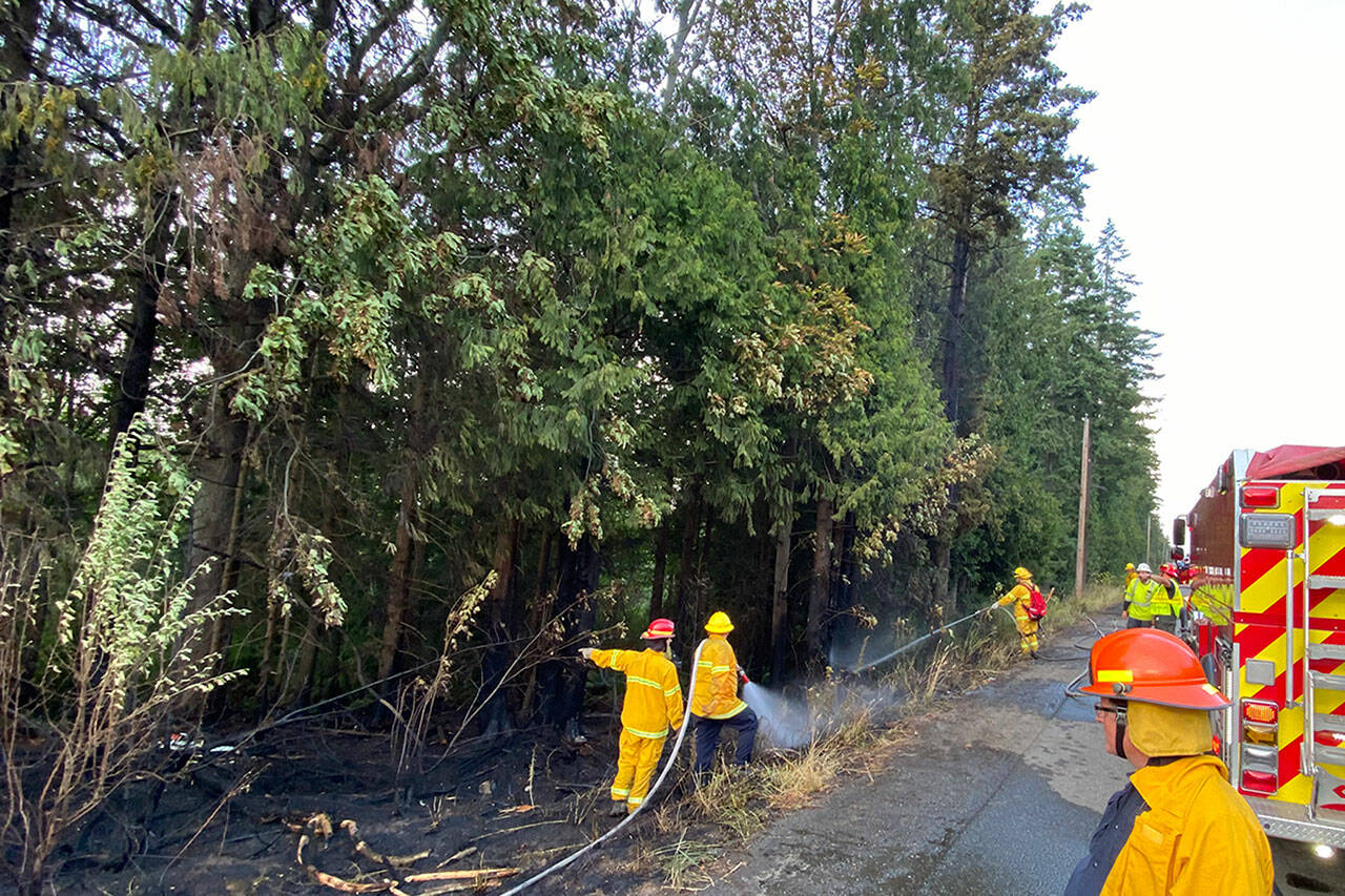 Photo courtesy Clallam County Fire District 3
Firefighters extinguish a fire along U.S. Highway 101 on Aug. 17 that caused traffic to be detoured.